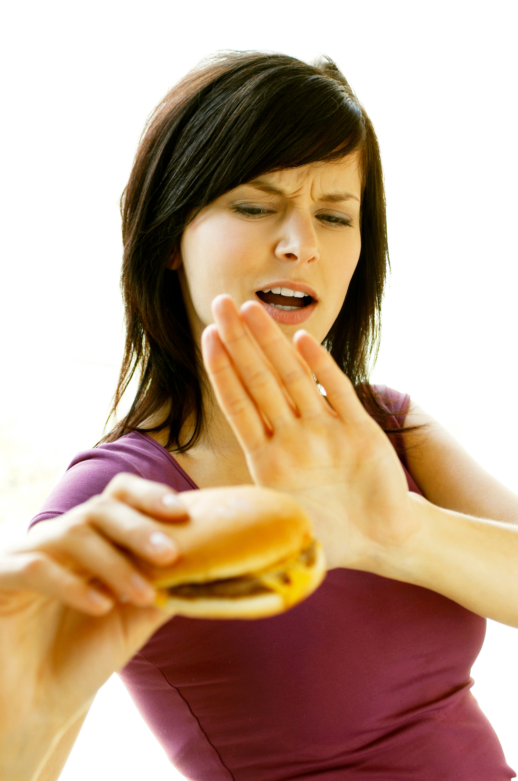 A lady refraining herself from eating a cheese burger