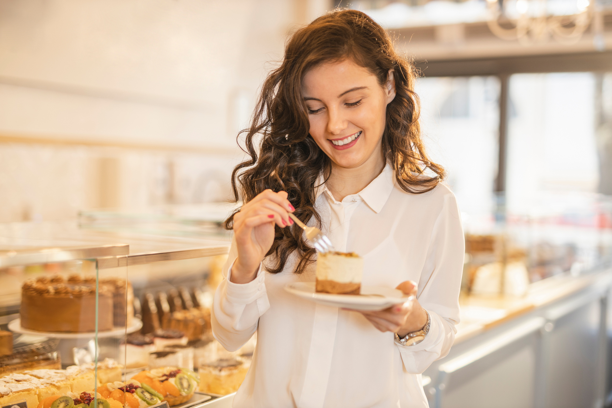 Woman eating cake at the cake shop